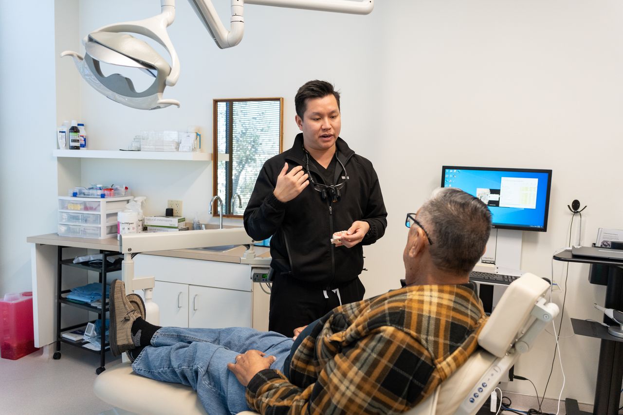 Dental implant pain consultation with Houston dentist explaining recovery expectations