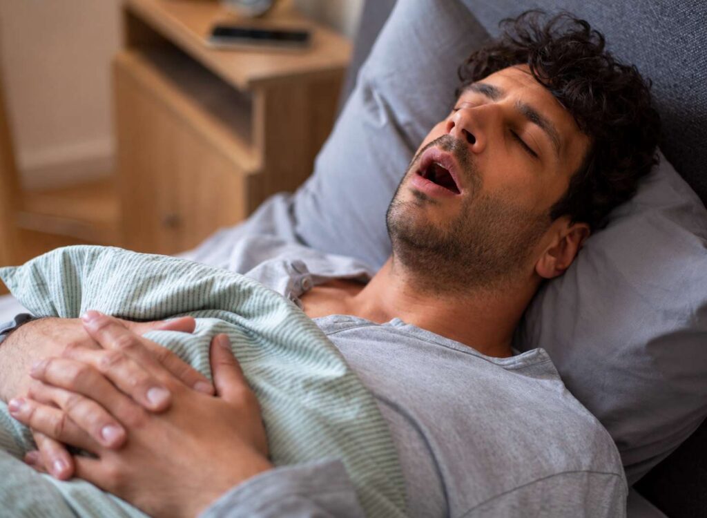 Houston man snoring at night before treatment with a sleep apnea mouth guard