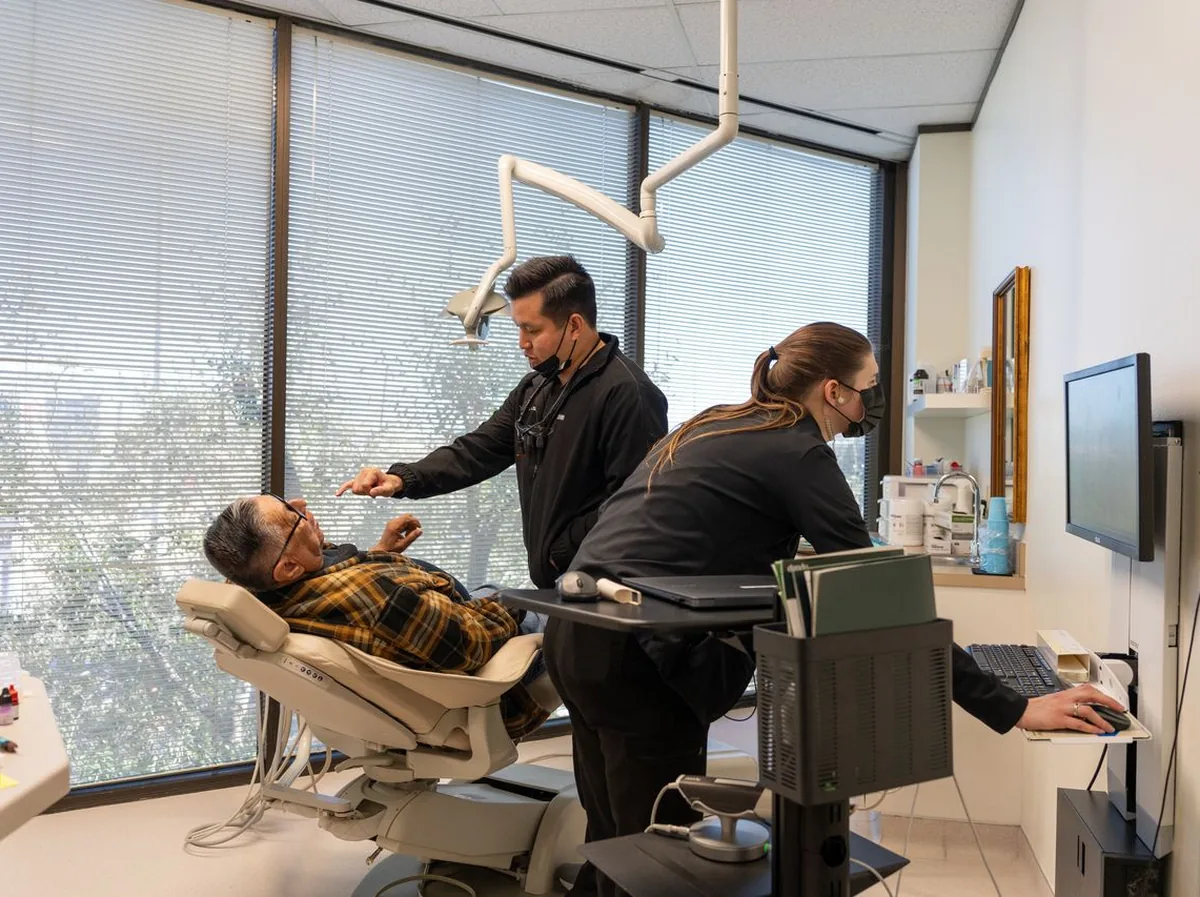 Dentist discussing deep teeth cleaning options with a patient at Henry Smiles Dental in Houston